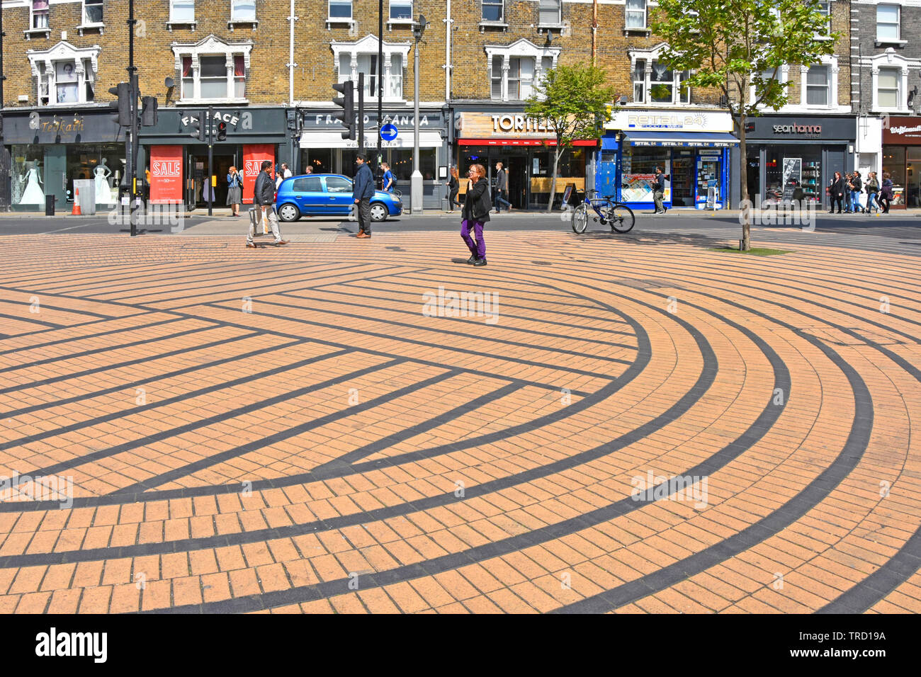 Wimbledon London Menschen in Shopping street scene Pflastersteine auf Kreise und Rechtecke in geometrische Form Muster mit farbigen Streifen England UK festgelegt Stockfoto