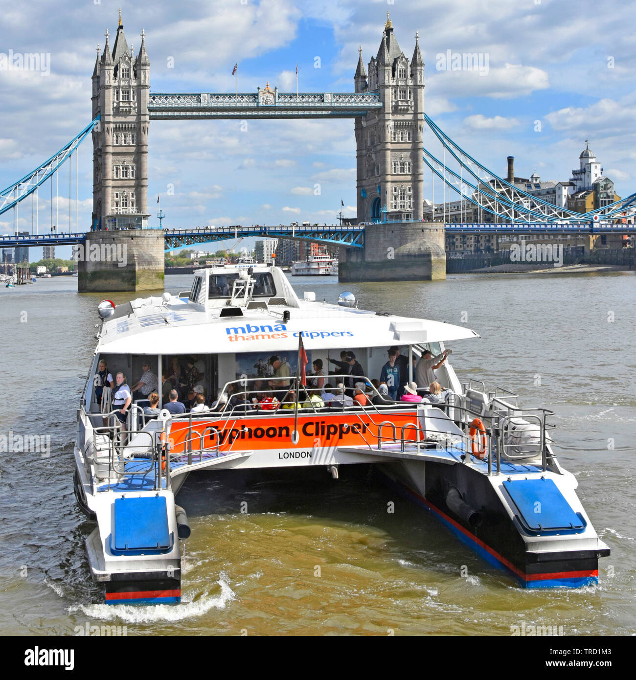 Touristen und Pendler auf high speed Thames Clipper Katamaran öffentliche Verkehrsmittel schnell Fluss-Bus mit Tower Bridge Wahrzeichen über London England Großbritannien Stockfoto