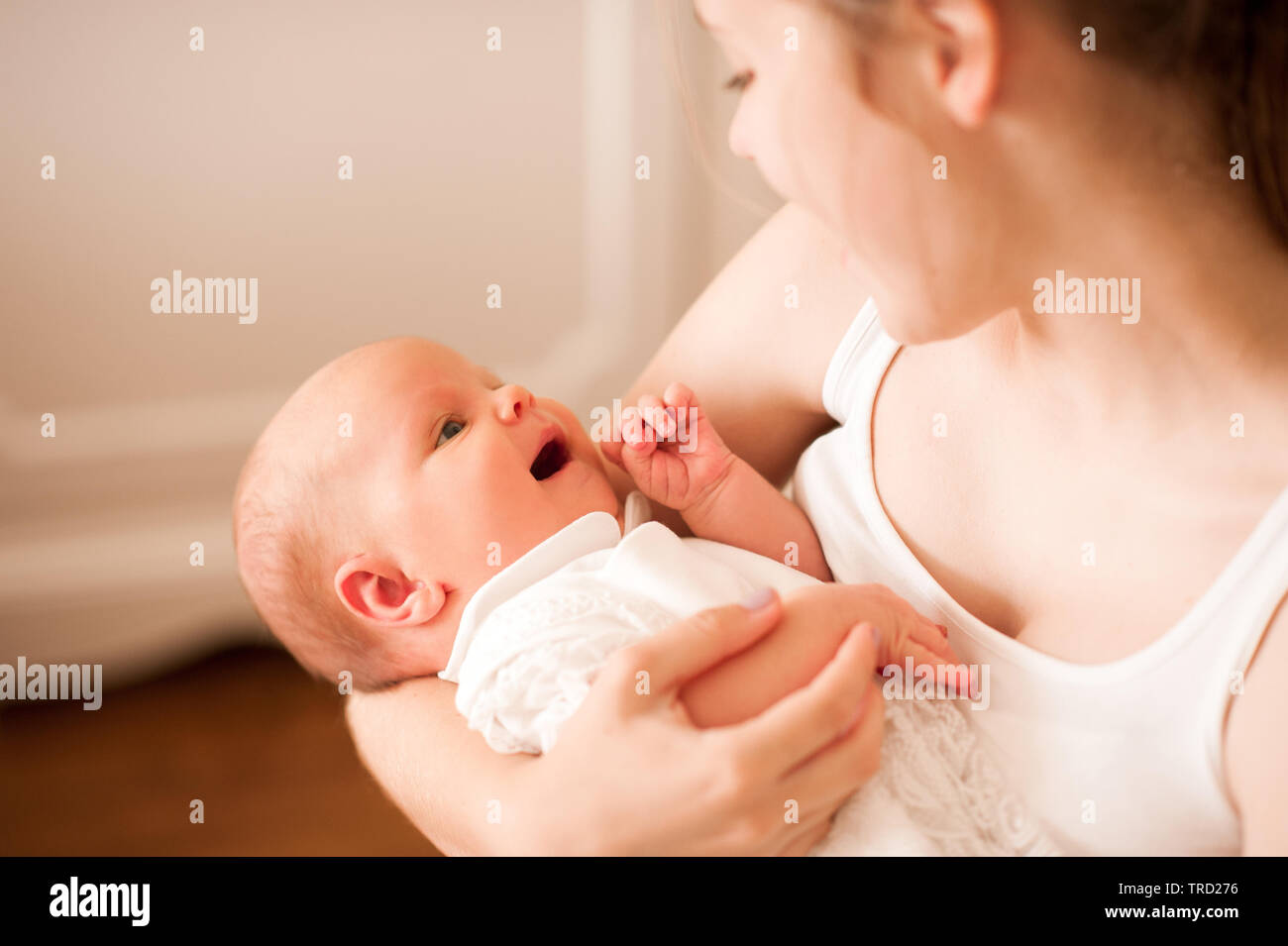 Lächelnde Mutter Kleine Kleinkind Baby zuhause. Schauen einander an. Mutterschaft. Die Mutterschaft. Zeit mit der Familie. Stockfoto