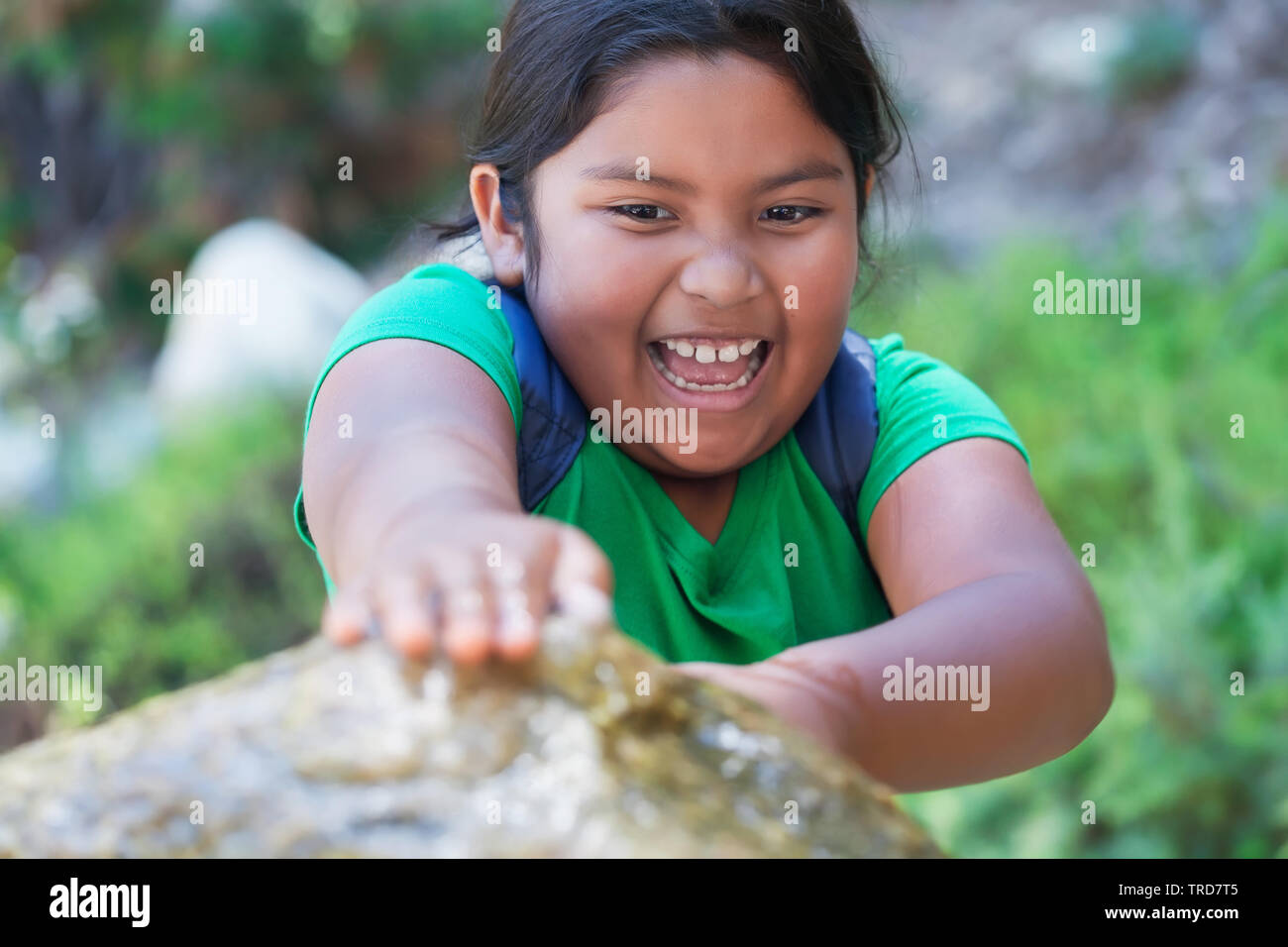 Pre teen Student mit Rucksack blockieren ein Brunnen mit den Händen und eine großartige Zeit spielen nach der Schule. Stockfoto