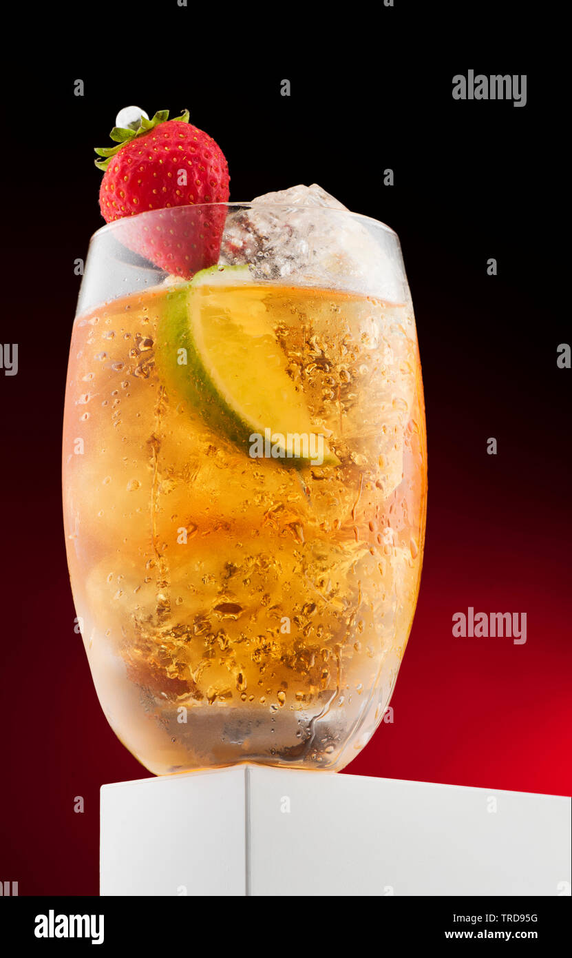 Cocktail mit gelben Flüssigkeit mit Obst, Erdbeere, Kalk und Eis Dekorationen Stockfoto