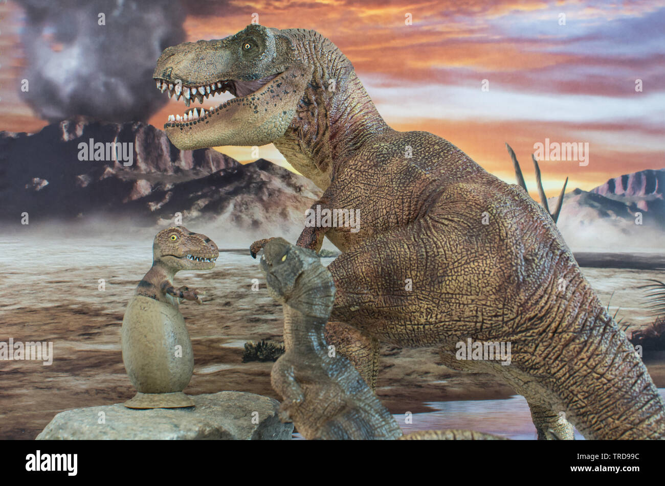 Süßes baby Tyrannosaurus rex in Ei mit Mutter Tyrannosaurus rex mit Vulkan im Hintergrund Stockfoto