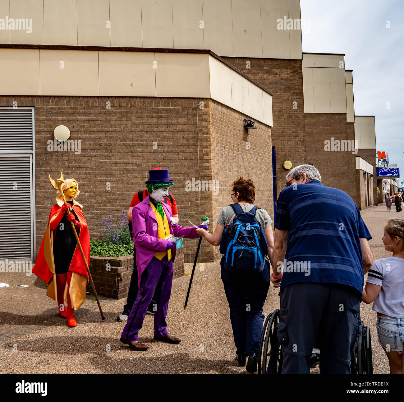 Great Yarmouth Comicon 2019 - Der Joker, Mario und ein super Heldin vor dem Eingang der Comicon Veranstaltung in der Küstenstadt Great Yarmouth Stockfoto