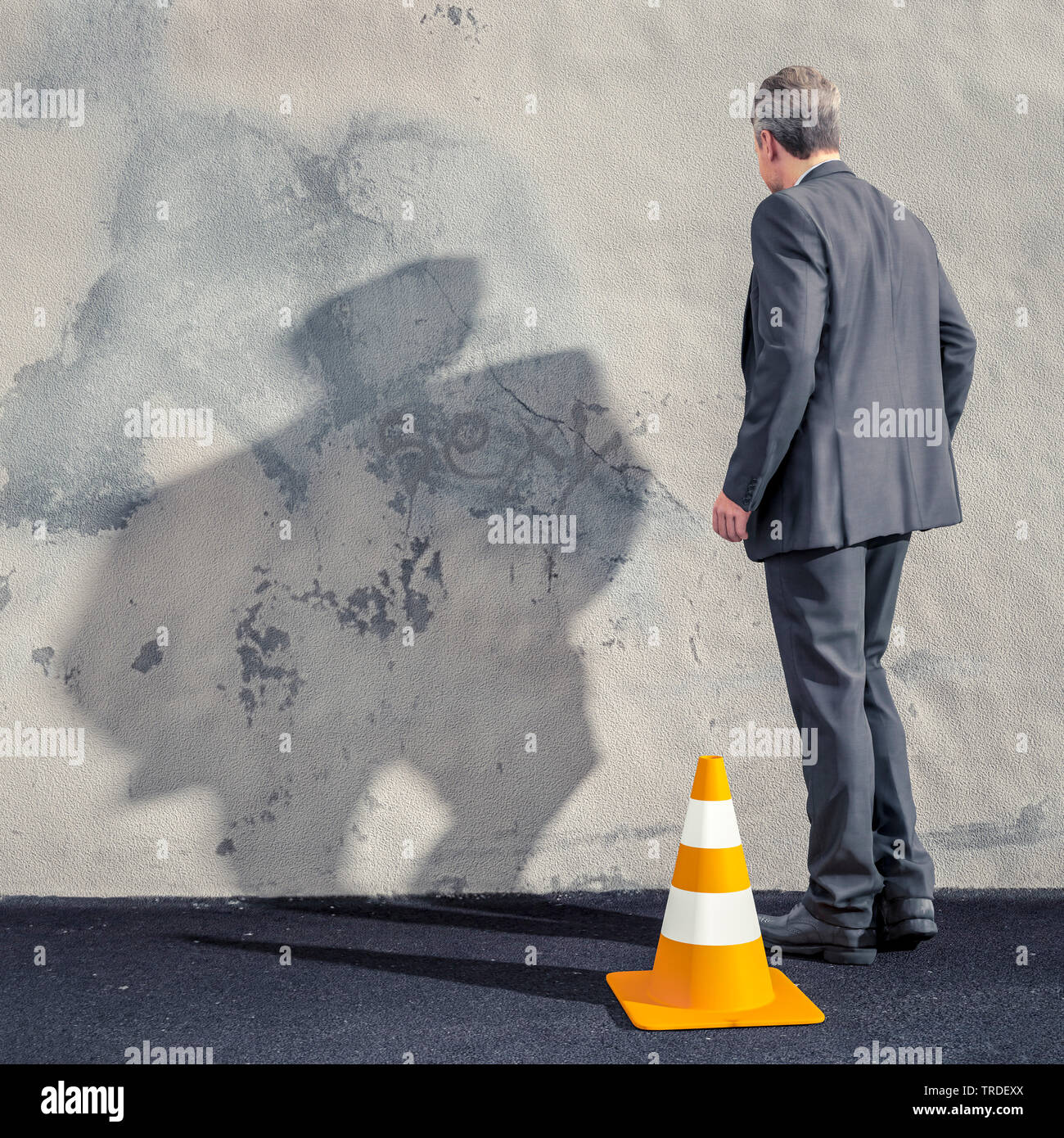 Rückansicht einer erschöpften business Mann mit hängenden Armen vor einer grauen Wand Stockfoto