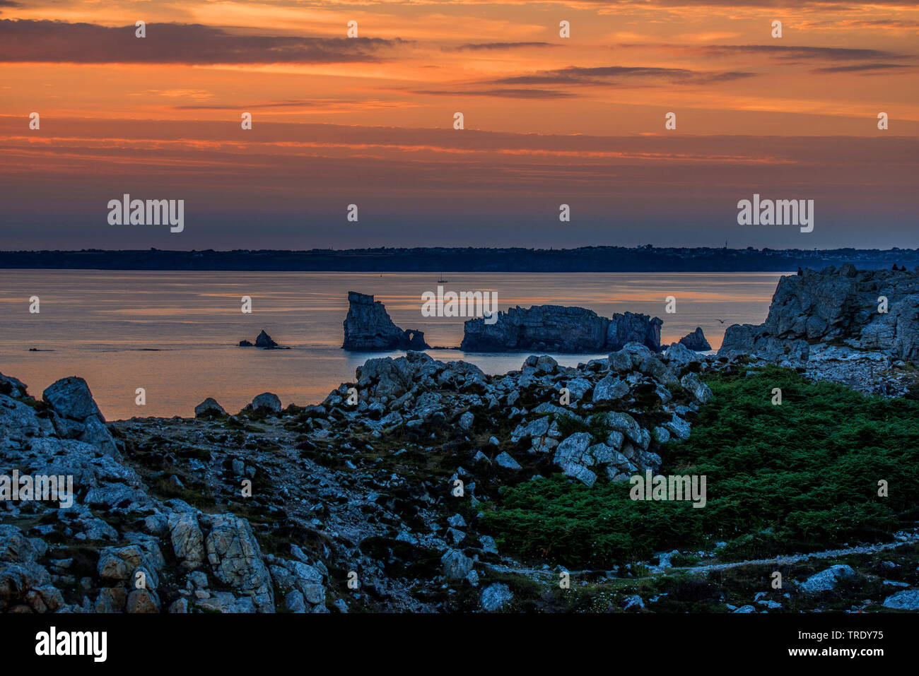 Atlantikküste Pointe de Spitze Penhir in den roten Sonnenuntergang, Frankreich, Bretagne, Crozon Stockfoto