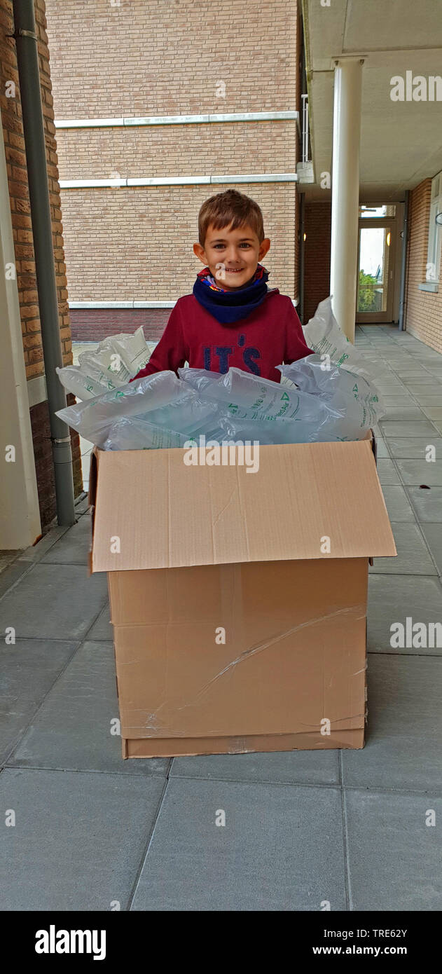 Kleiner Junge in einem Paket mit einer großen Menge von Luftkissen, Deutschland Stockfoto