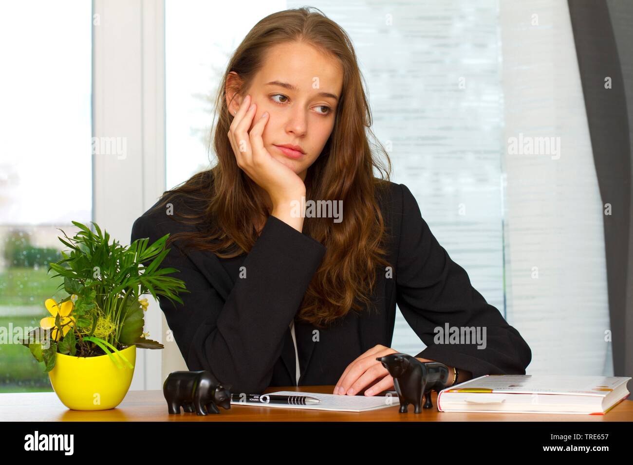Porträt einer jungen Frau am Schreibtisch sitzen und traurig Stockfoto