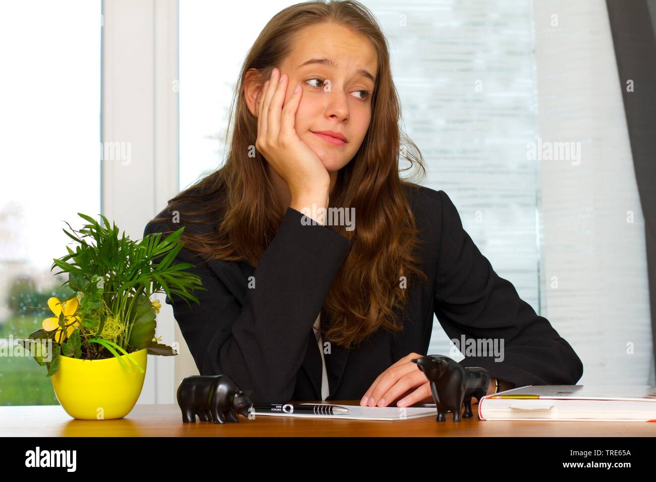 Porträt einer jungen Frau am Schreibtisch sitzen und verträumt auf der Suche Stockfoto