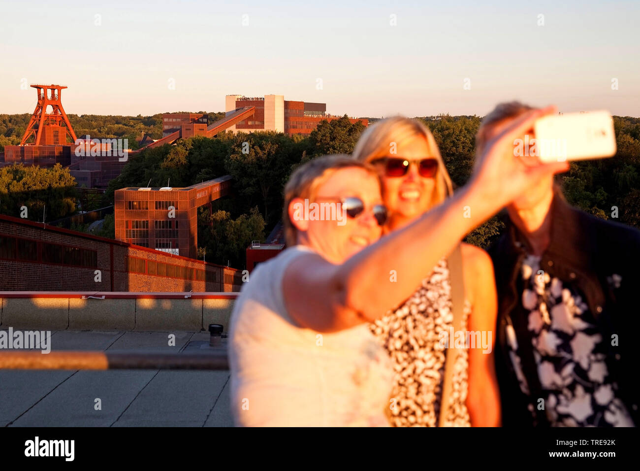 Drei Frauen, die eine selfie vor der Zeche Zollverein, Schacht XII, Deutschland, Nordrhein-Westfalen, Ruhrgebiet, Essen Stockfoto