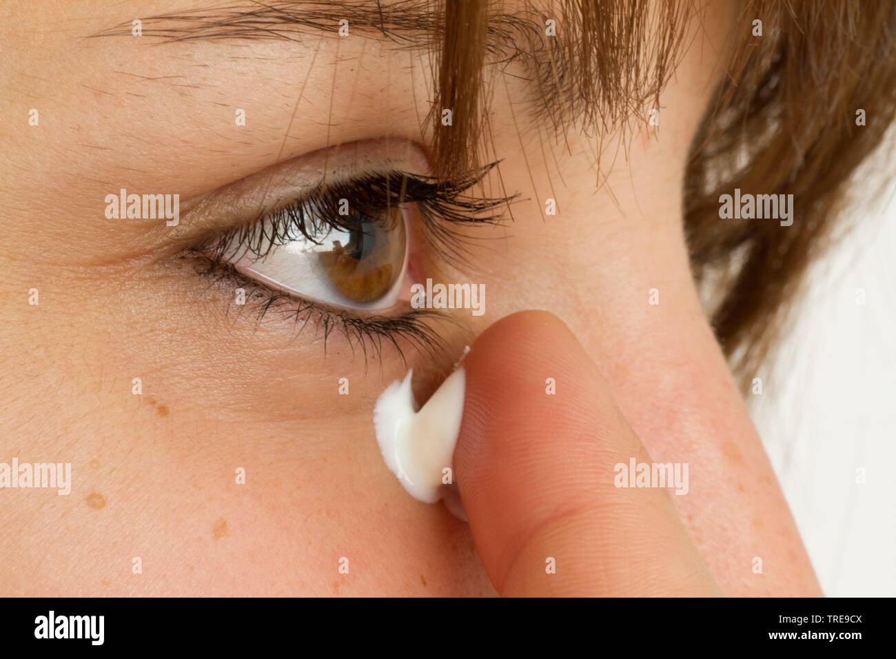 Junge sympathische Frauen ihren Finger Holding mit Gesichts Creme auf der Haut Stockfoto
