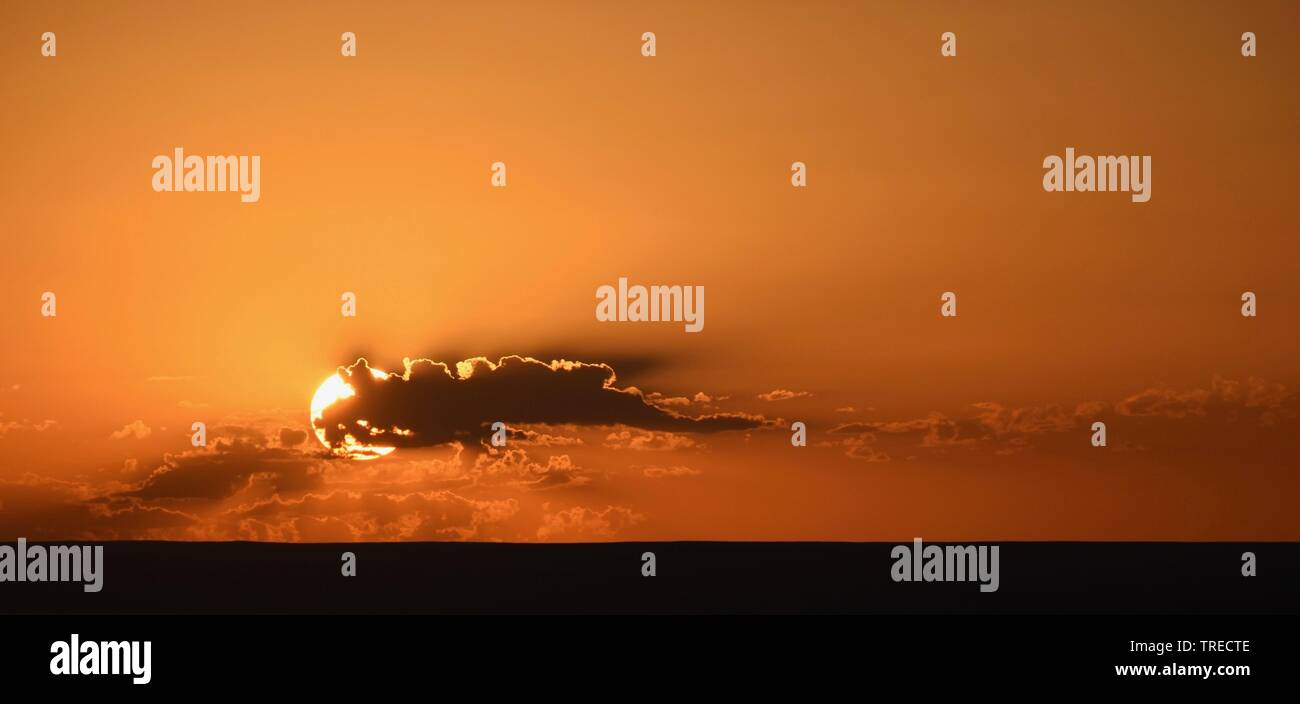 Einfach orange Sonnenuntergang hinter Wolken Stockfoto