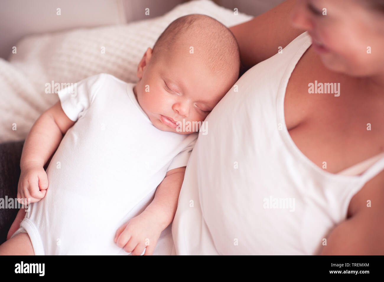 Lächelnde Mutter halten Schlafen Baby auf Hände im Zimmer. Die Mutterschaft. Mutterschaft. 20. Stockfoto