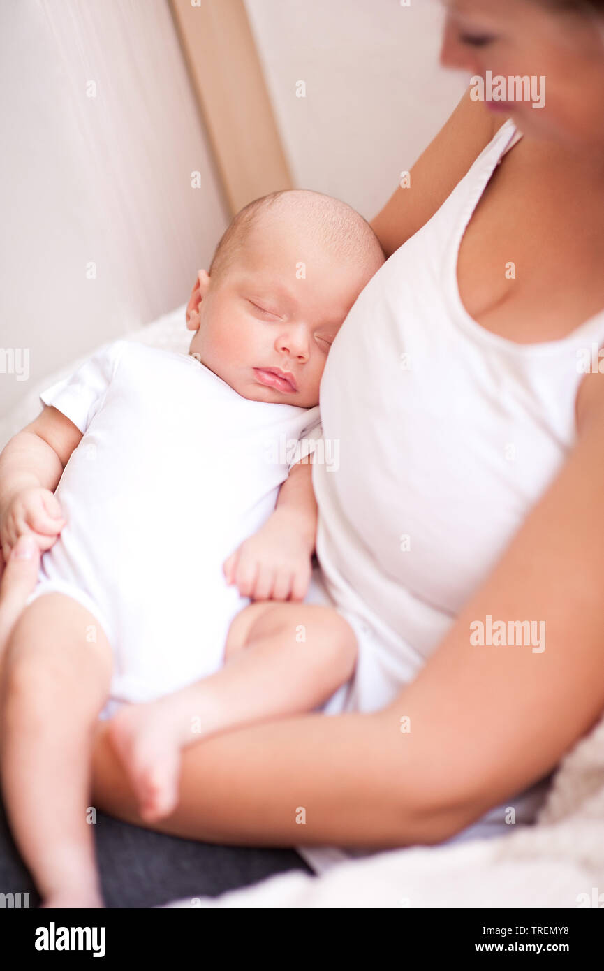 Lächelnde Mutter ihr schlafendes Baby Holding auf Händen hautnah. Die Mutterschaft. 20. Stockfoto