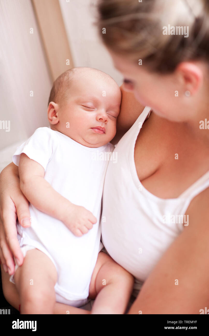 Mutter Holding sleeping baby auf Händen drinnen. Die Mutterschaft. Glück. 20. Stockfoto