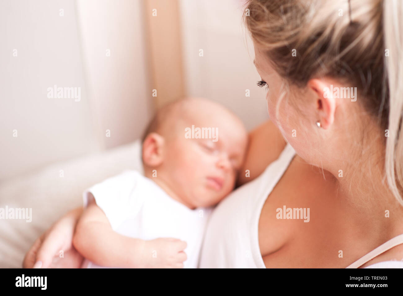 Mutter Holding sleeping baby auf Händen im Zimmer. Die Mutterschaft. Mutterschaft. Selektive konzentrieren. Stockfoto