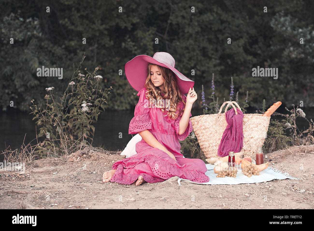 Lächelnd jugendlich Mädchen 14-16 Jahre alten tragen einen grossen Hut und Rosa vintage Kleid im Freien. In Picknick im Park. Sommer. Stockfoto