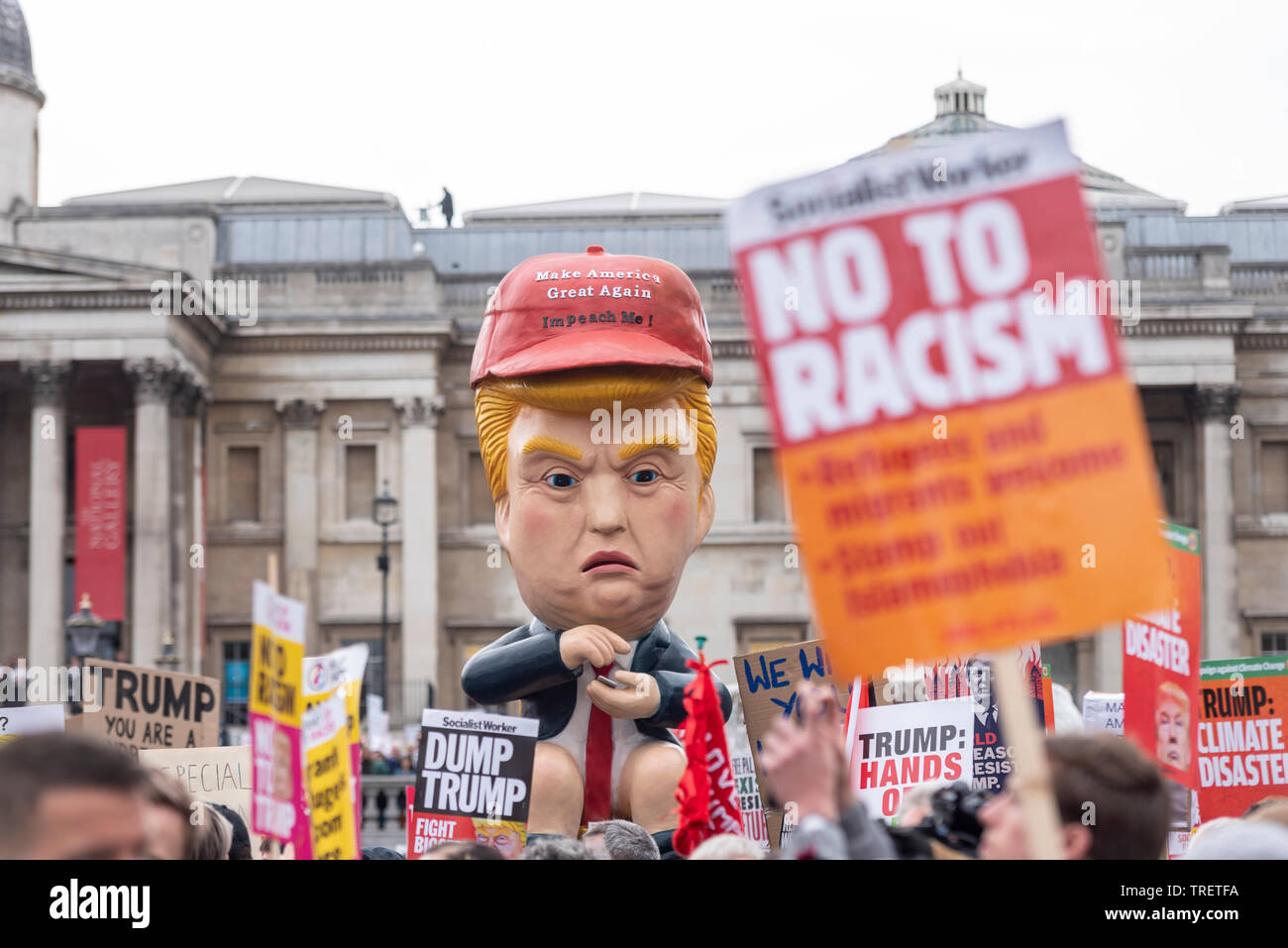 Die Demonstranten haben am Trafalgar Square, London, UK mit der Absicht protestieren gegen und stören Donald Trump Staatsbesuch in Großbritannien gesammelt. Ein Bildnis des Donald Trump twittern, während auf einer Toilette saß Prominente Stockfoto