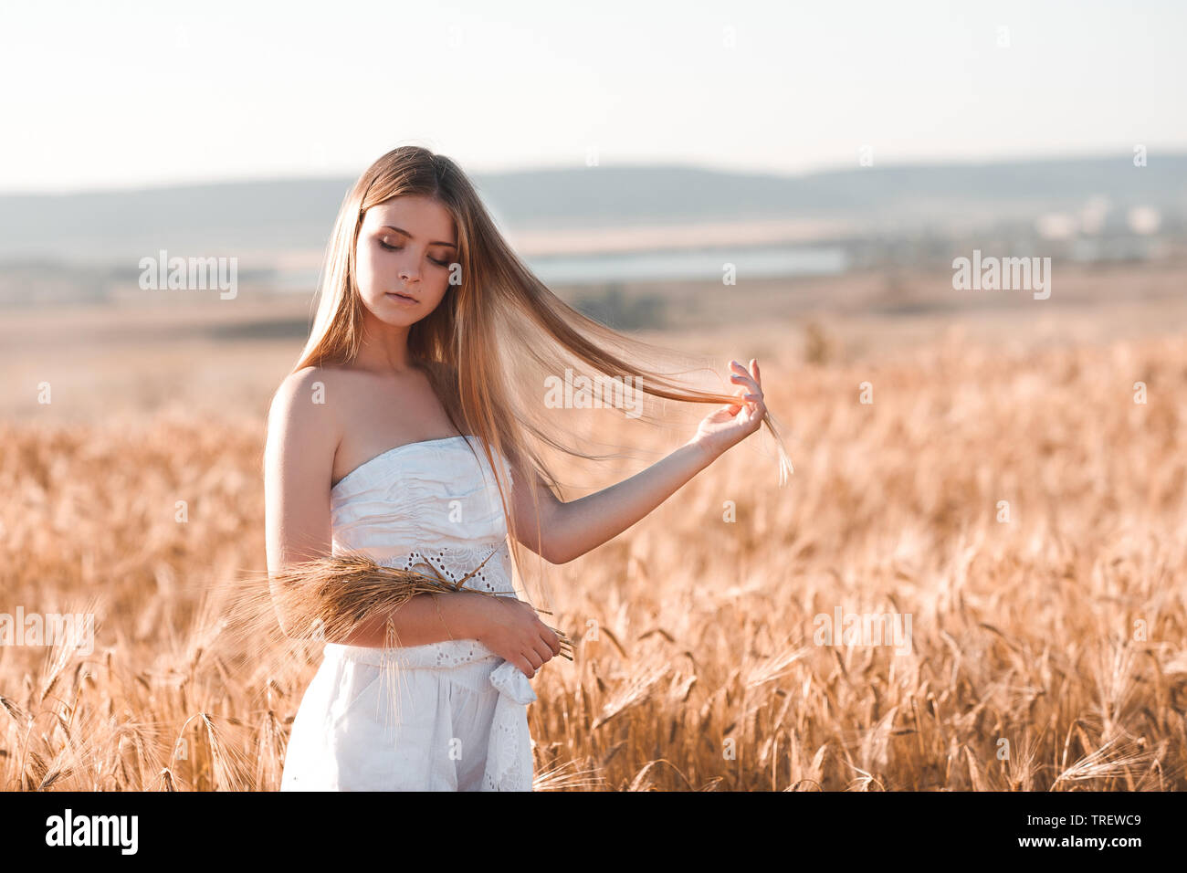 Schöne blonde Teenager Mädchen 14-16 Jahre alten Holding Weizen im Freien. Sommer Saison. 20. Stockfoto
