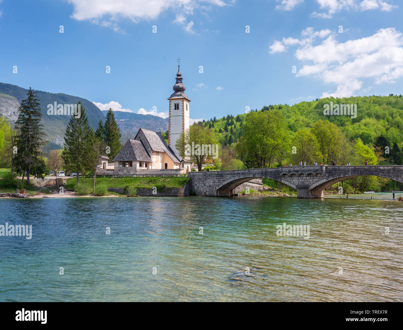 St. Johannes der Täufer Kirche in Bohinj See in das zweimal jährlich erscheinende Mode-Special Zeit. Gewölbten Steinbrücke über die klaren Wasser der Sava Bohinjka. Großes Ziel für alle sehen Stockfoto