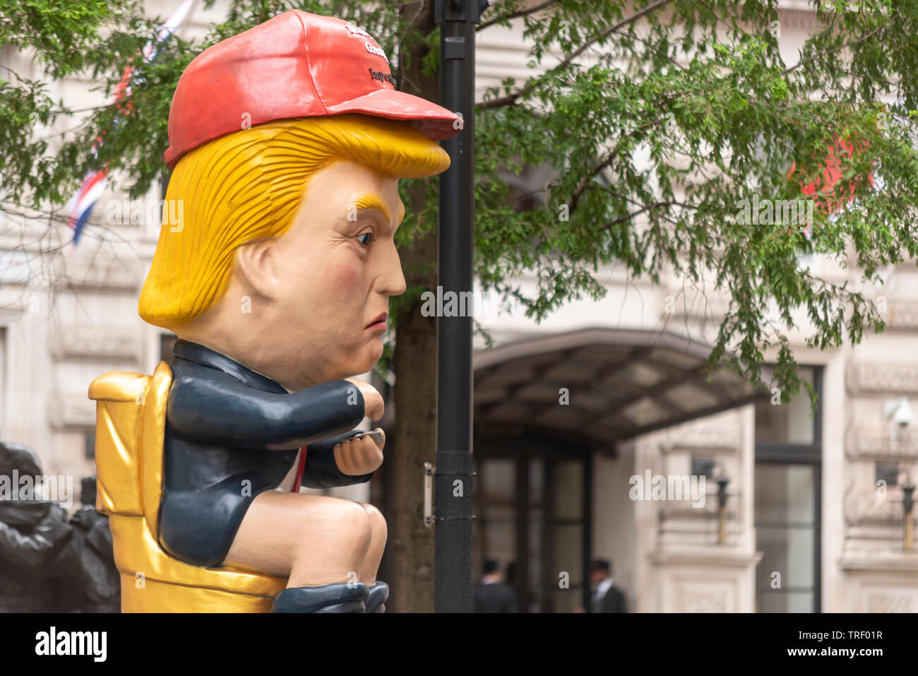 Die Demonstranten haben außerhalb der Corinthia Hotel, Westminster, London, UK, wo Donald Trump angeblich hat eine ganze Etage für seine Familie gebucht. Ein Bildnis des Donald Trump twittern, während auf einer Toilette saß Prominente Stockfoto