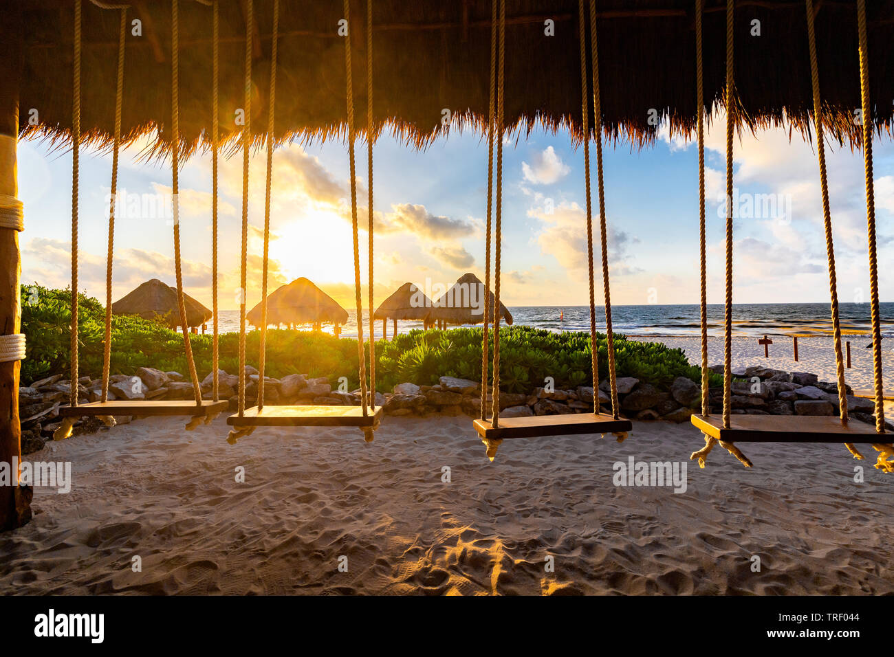 Schaukeln hängen in einer Hütte auf der Valentin Imperial Maya all inclusive Resort aus über das Meer und den Sonnenaufgang. Stockfoto