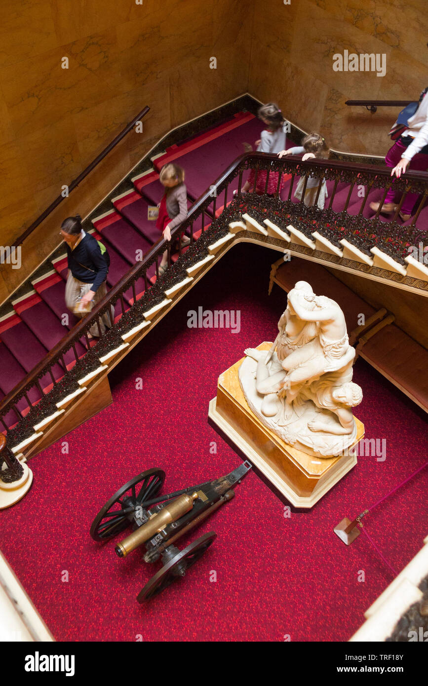 Innen/Innen von Osborne House auf der Isle of Wight; am Fuße der wichtigsten Auftraggeber Treppe die Statue "Die Amazonen und Argonaut" ist auf dem Display neben einem alten Barrel Of A Gun Cannon. Isle of Wight, Großbritannien Stockfoto