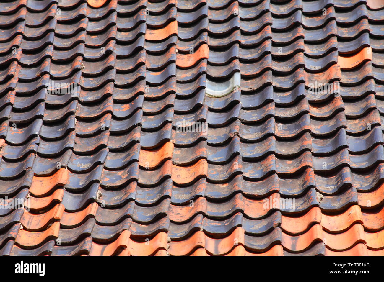 Rote und dunkle Dachziegel, Dachziegel, alten, baufälligen Dach Stockfoto