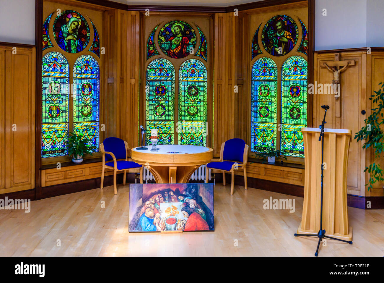 Gemälde des Letzten Abendmahls neben dem Altar in einem kleinen Römisch-katholische Kapelle mit verzierten Buntglasfenster hinter sich. Stockfoto