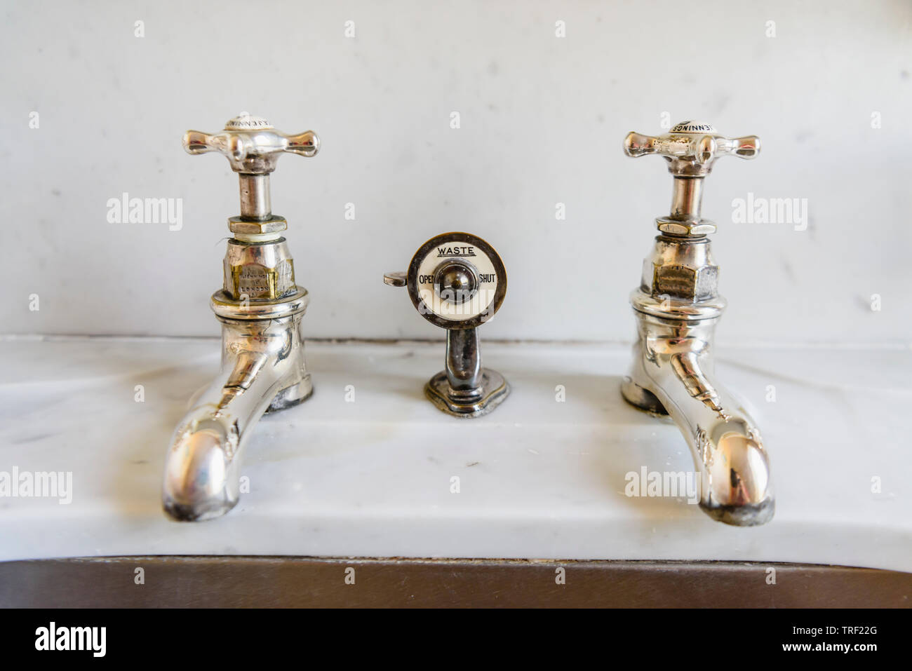 Altmodische tippt auf ein Waschbecken aus Marmor, mit einem Ventil den Stecker zu kontrollieren. Stockfoto