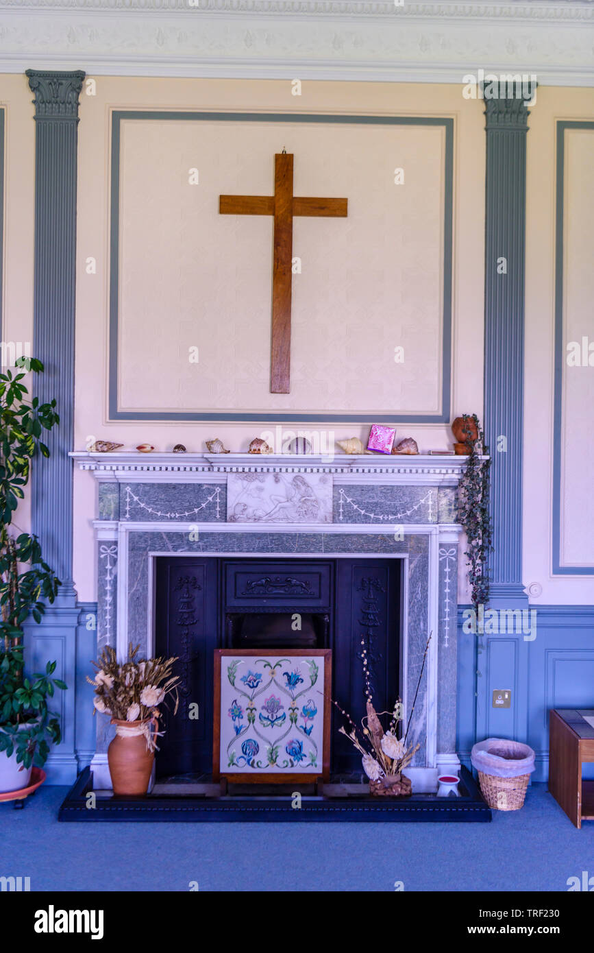Holzkreuz über dem Kamin im Wohnzimmer, im viktorianischen Stil dekoriert. Stockfoto