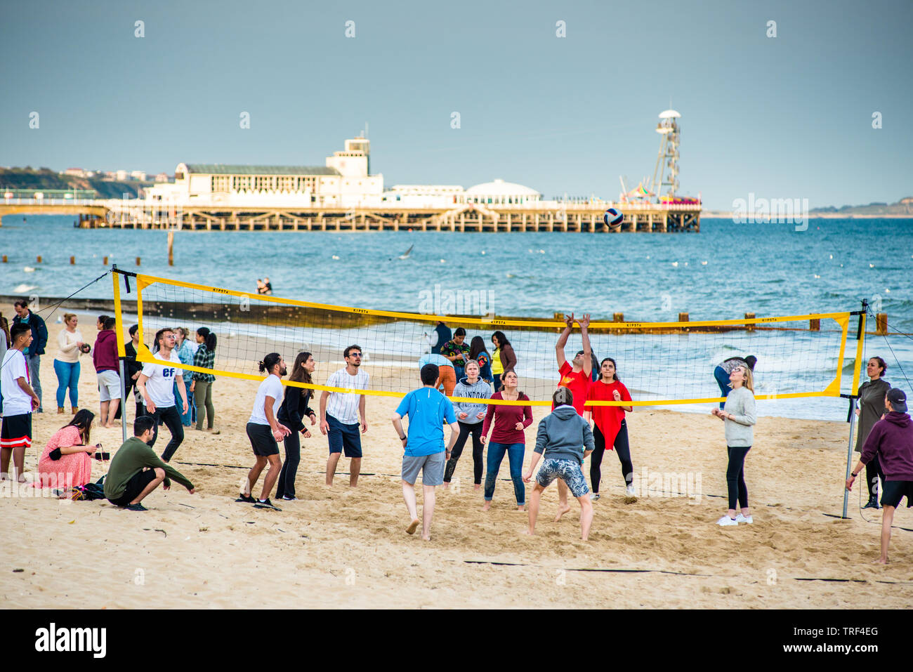 Volleyball am Strand von Bournemouth mit der Pier nach hinten. Dorset. England, UK. Stockfoto