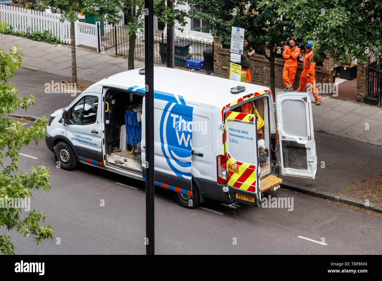 Ein Thames Water Wartung van und drei männliche Arbeitnehmer, die von der Seite der Straße in Islington, London, UK Stockfoto