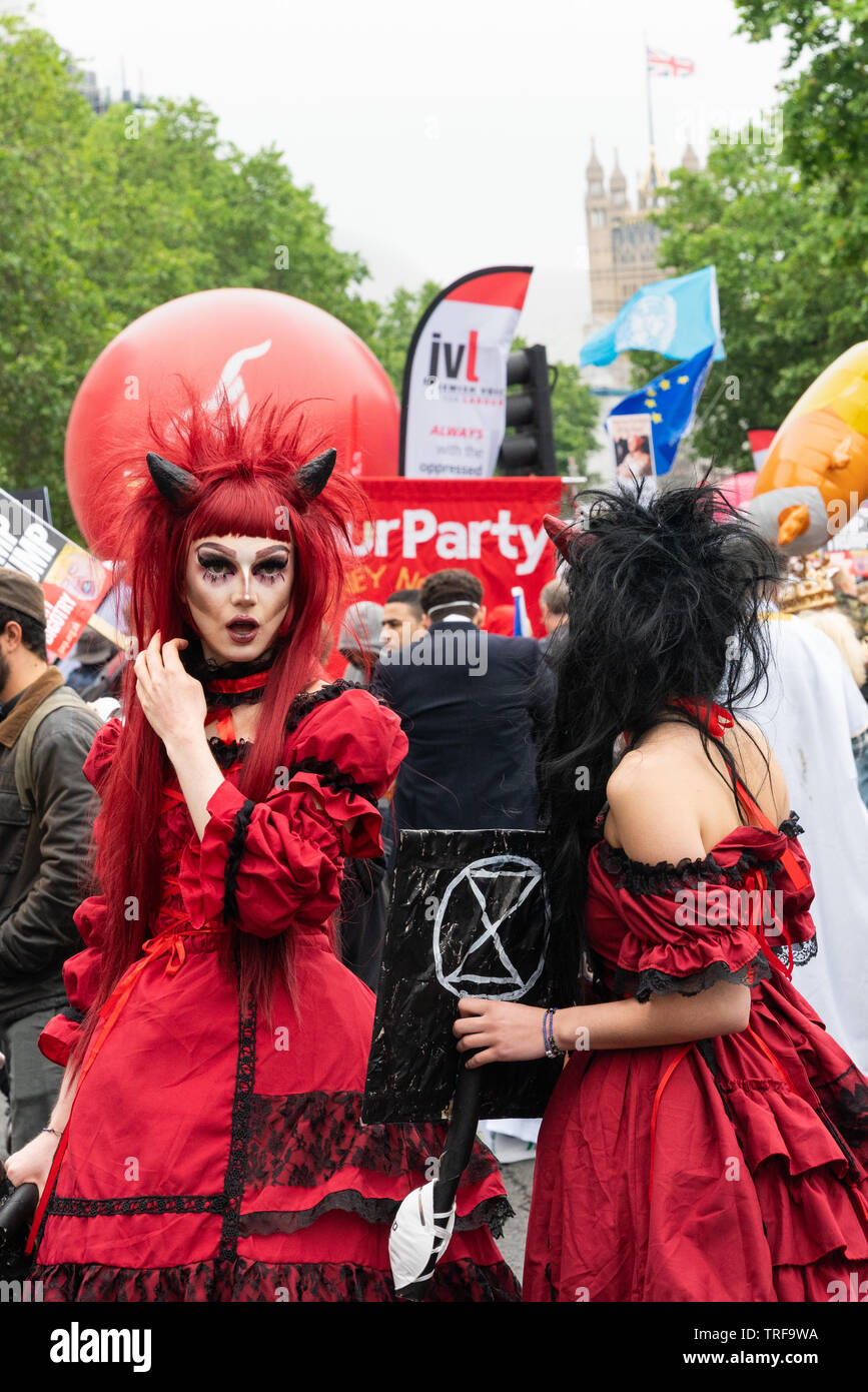 4. Juni 2019. London, Großbritannien. Anti Trump Rallye in Westminster. Eine Frau in Teufel Kostüm hält Aussterben Rebelion Plakat im Trump protestieren. Stockfoto