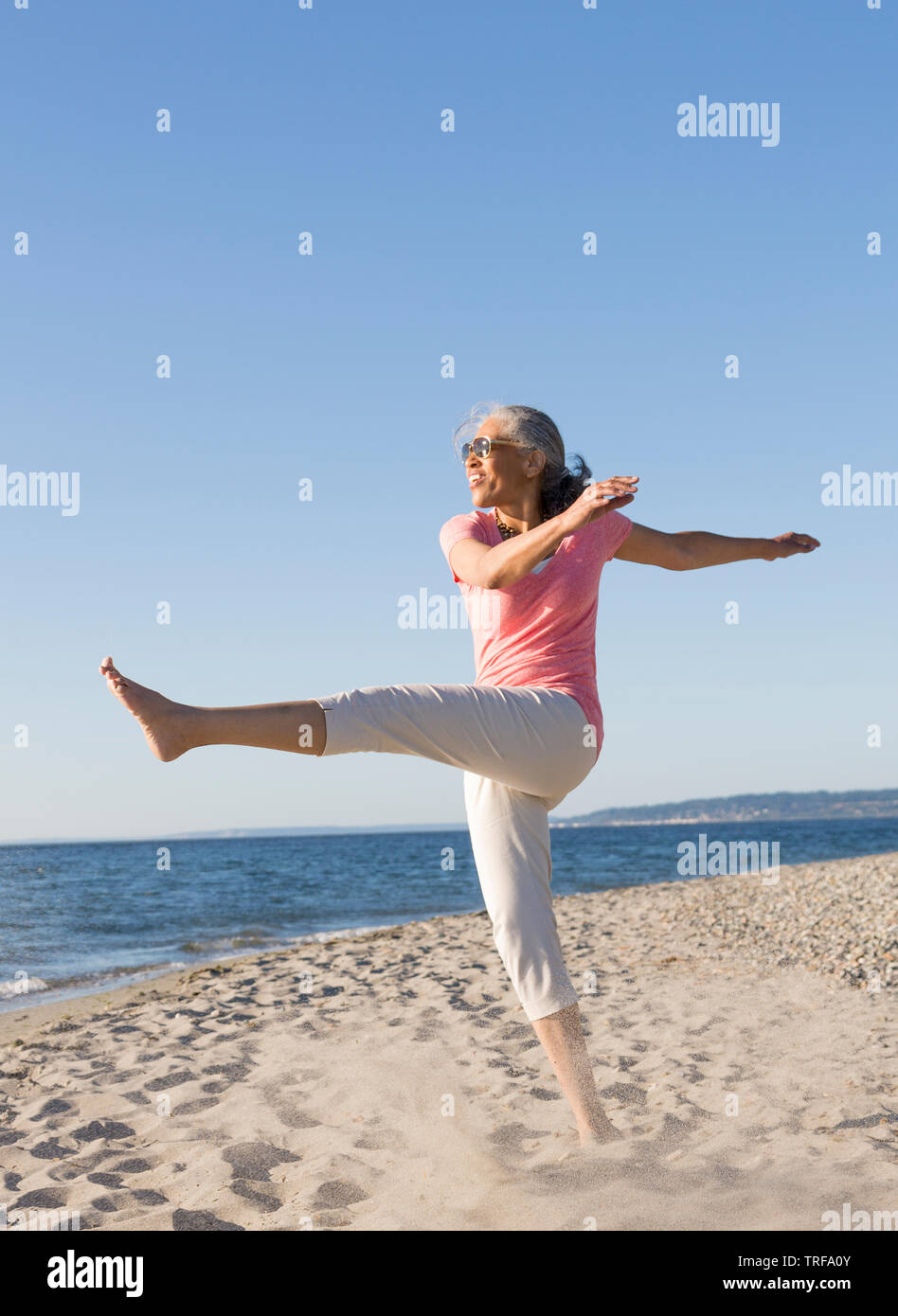 Glücklich, im mittleren Alter, schwarz, afrikanische amerikanische Frau mit Sonnenbrille, Spaß am Strand im Sommer. Aktive, gesunde, reife Lebensstile. Stockfoto