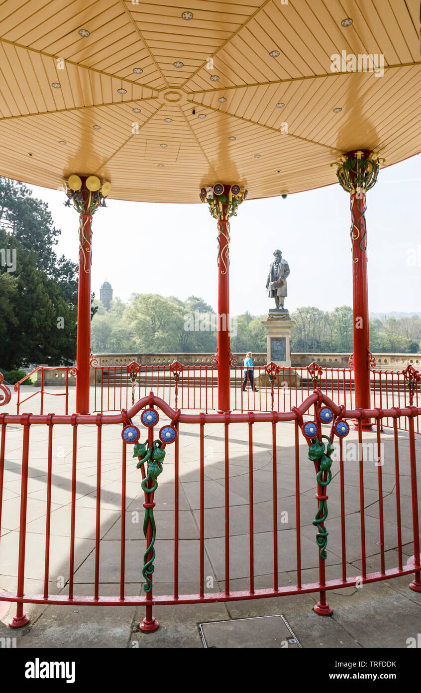 Blick durch den Musikpavillon in Richtung der Statue von Sir Titus Salt in Roberts Park, Saltaire, Bradford, West Yorkshire Stockfoto