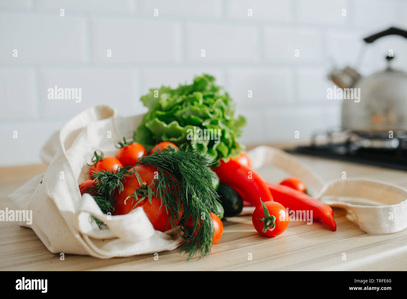 Frisches Grün und Rot Bio Gemüse in Leinen eco Beutel auf den Tisch in der Küche. Gesunder Lebensstil Stockfoto