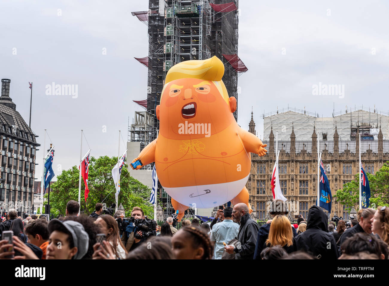 Donald Trump baby blimp Ballon in Parliament Square, London, UK während der US-Präsident auf Staatsbesuch. Fliegen über Menschen vor dem Parlament, Großbritannien Stockfoto