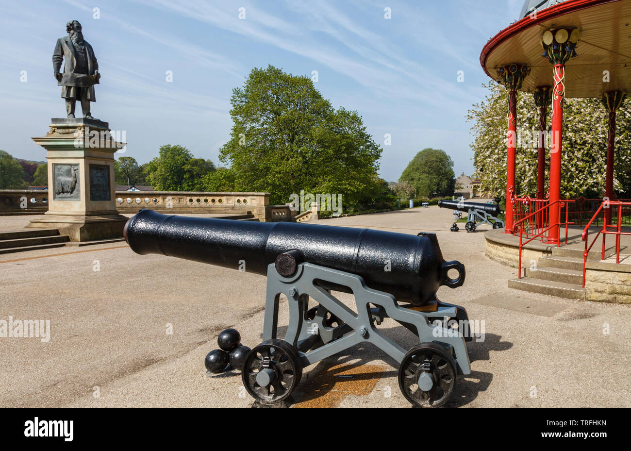 Zwei Colonel William Dundas Kanonen auf beiden Seiten der Musikpavillon, mit der Statue von Sir Titus Salt, Roberts Park, Saltaire, Bradford, West Yorkshire Stockfoto