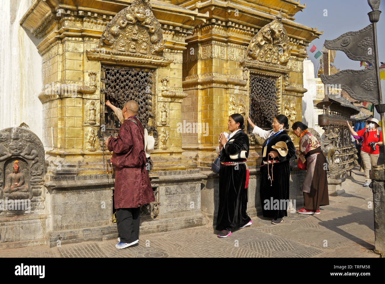 Der tibetischen Pilger in traditioneller Kleidung Anbetung an vergoldeten Nischen der großen buddhistischen Tempel Swayambhunath Stupa in Kathmandu Kathmandu Tal, N Stockfoto