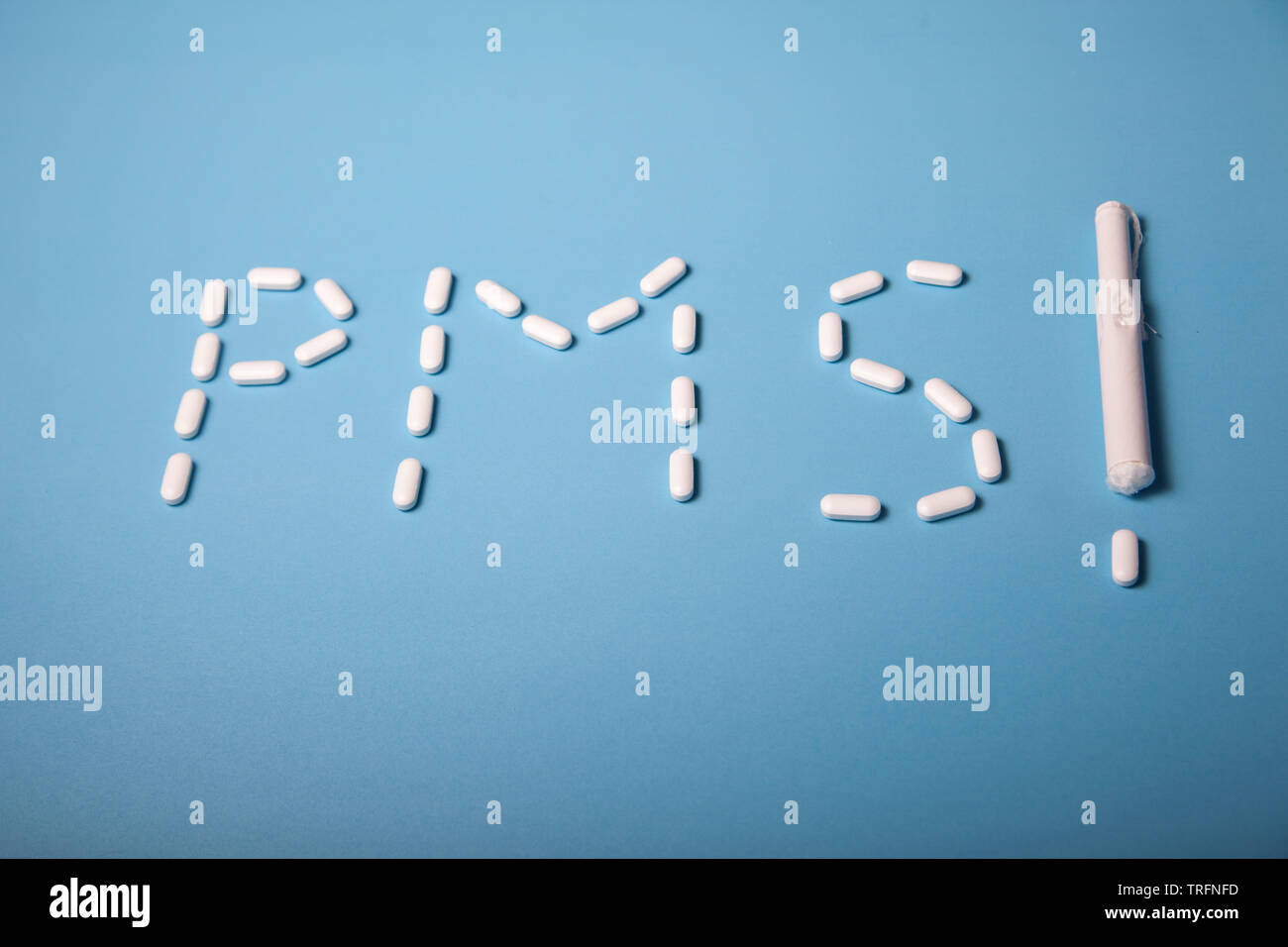 Das Wort PMS mit Schmerzlinderung Pillen geschrieben, sowie ein tampon Ausrufezeichen Stockfoto