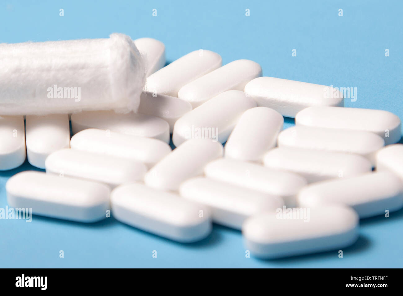 Zeitraum oder PMS kommt, mit einer Sammlung von Medikamenten und einem tampon vor einem blauen Hintergrund Stockfoto
