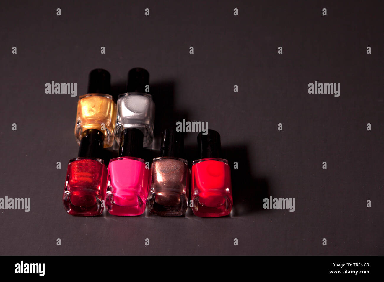 Gold, Silber, Rot und rosa Farbtönen von Nagellack gegen schwarze Kopie Raum Stockfoto