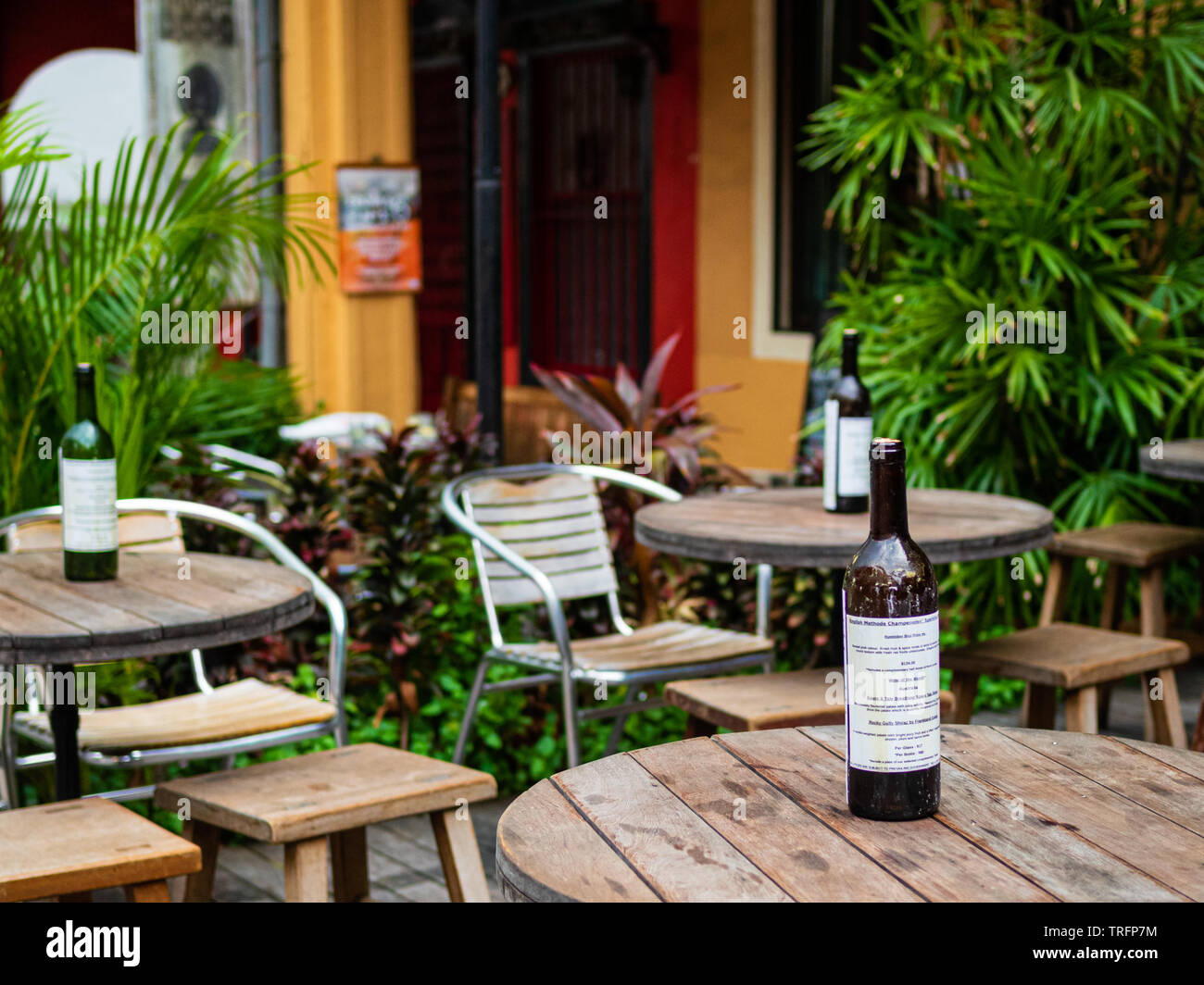 Ein zwangloses Speisen im Freien westlichen Cafe mit rustikalen Holzmöbeln, Pflanzen und Weinflaschen. Stockfoto