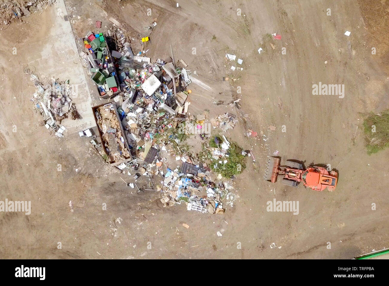 Orange Traktor arbeiten in einer Mülltrennung und Recycling Anlage, Luftaufnahmen. Stockfoto
