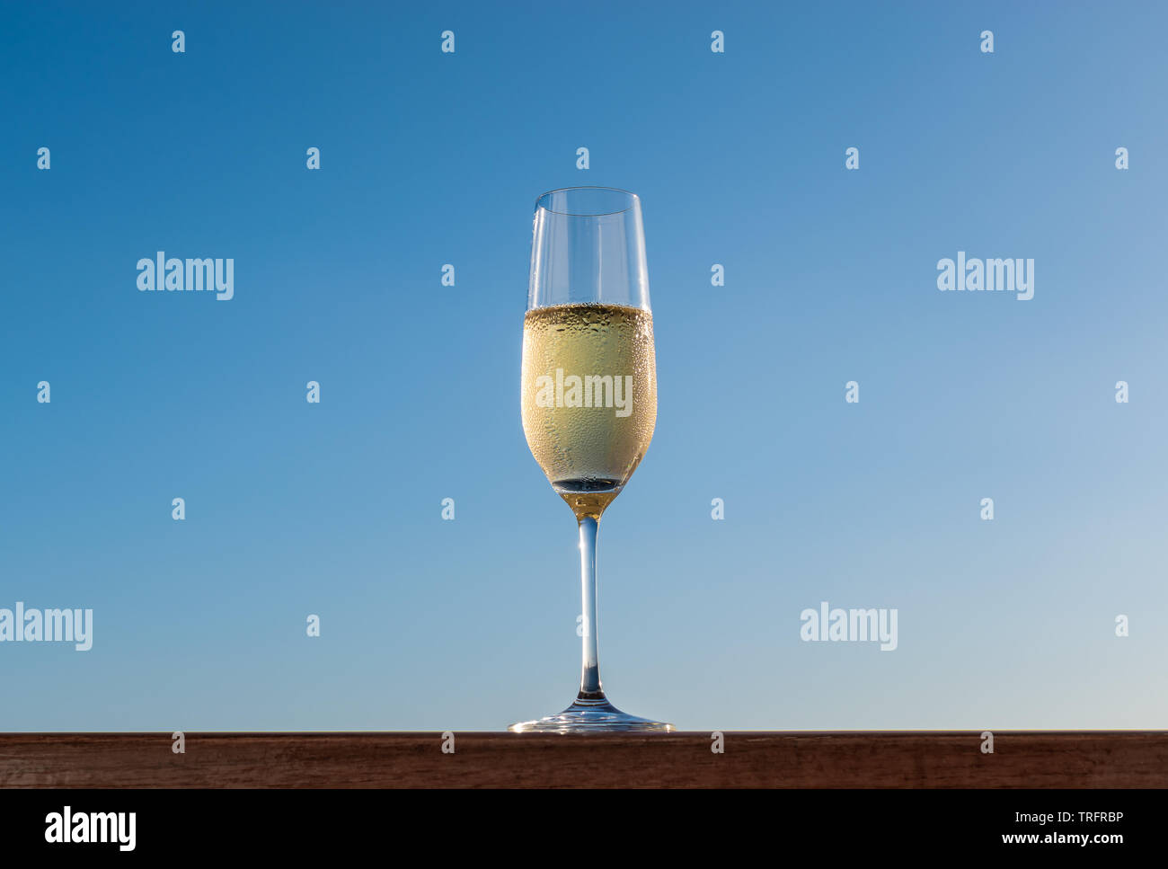 Ein Glas Champagner auf blauen Himmel Hintergrund isoliert. Stockfoto