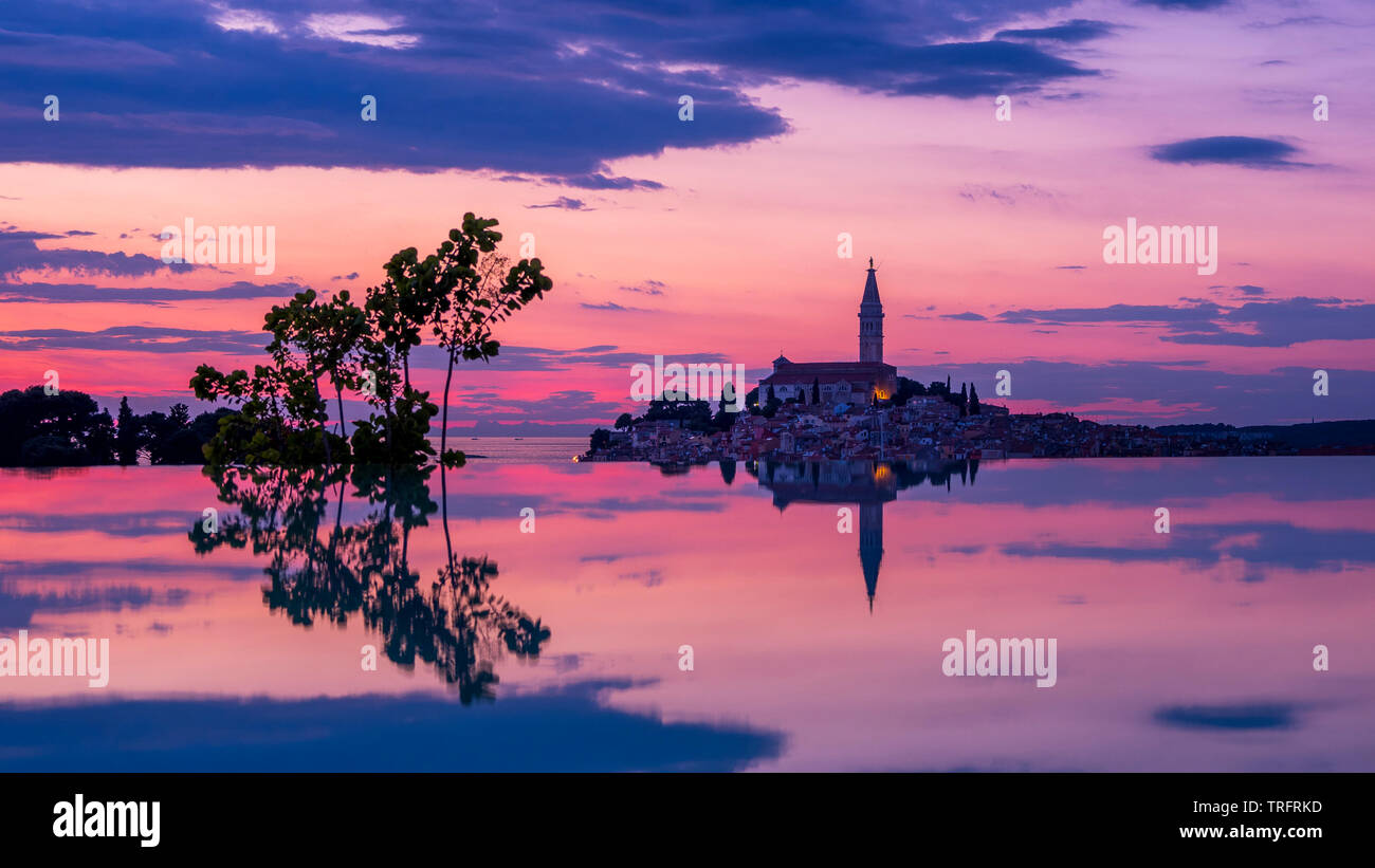 Sonnenuntergang im Pool mit Rovinj im Hintergrund reflektiert Stockfoto