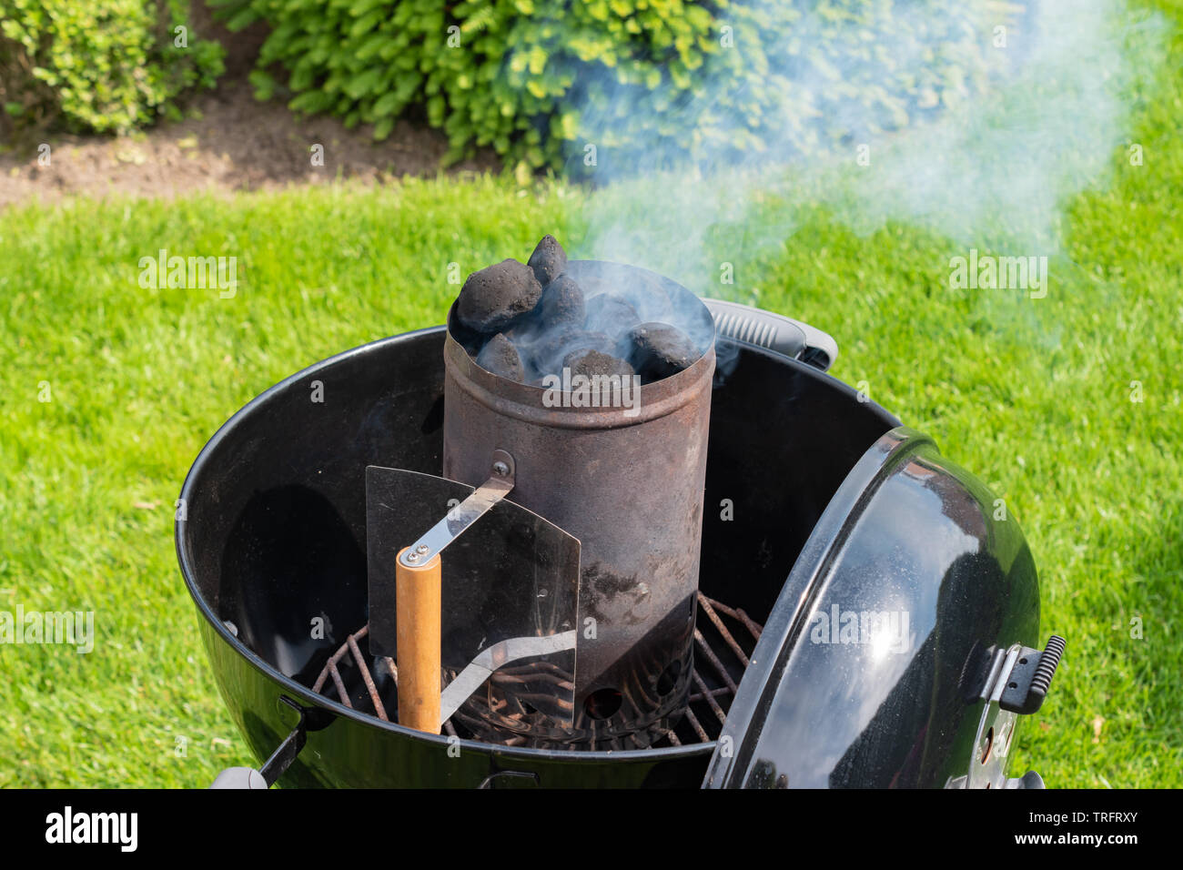 Rauchen Holzkohle Chimney Starter für Grill. Stockfoto