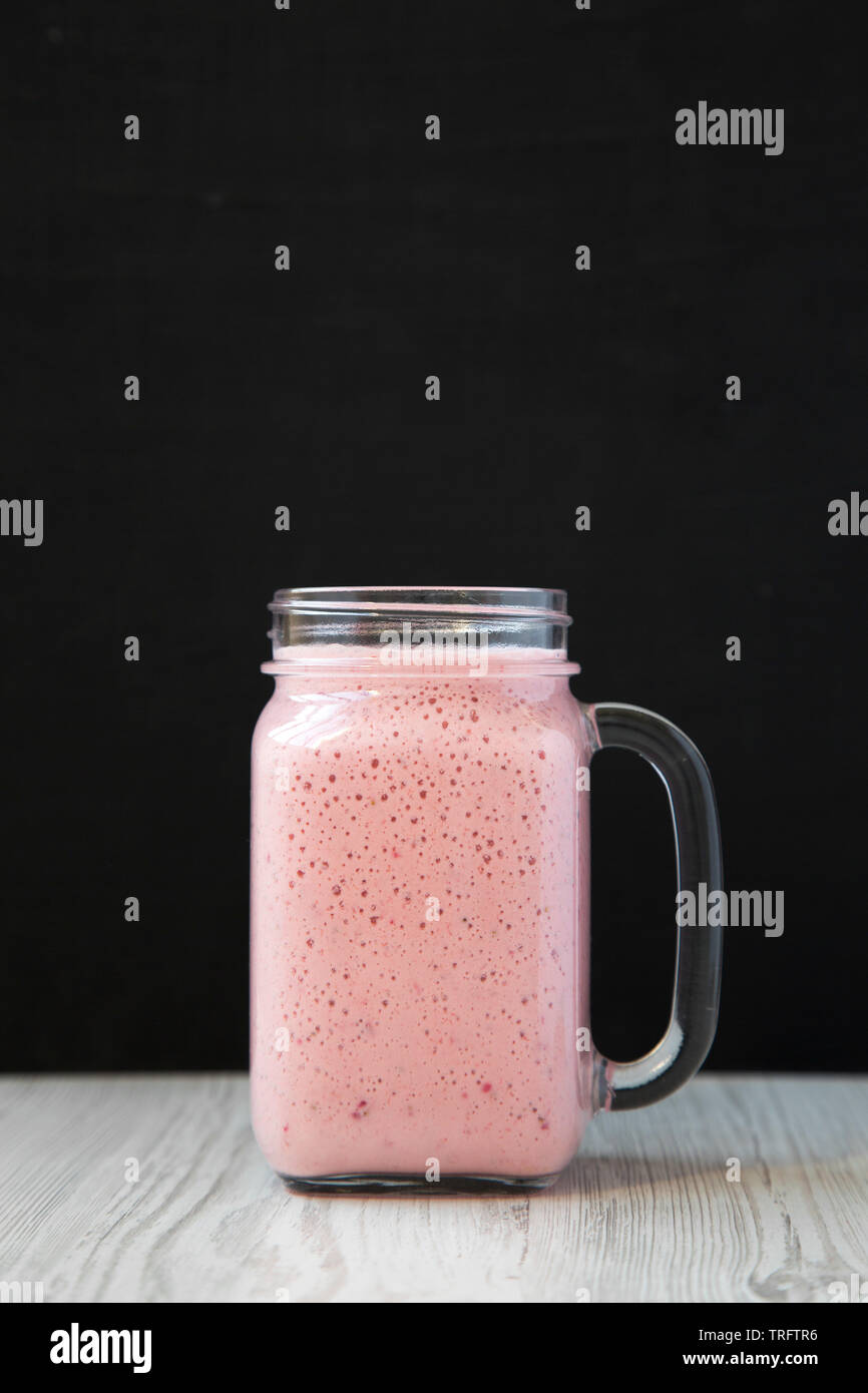 Mason Glas Glas Becher gefüllt mit Erdbeer Banane Smoothie, Seitenansicht. Close-up. Stockfoto