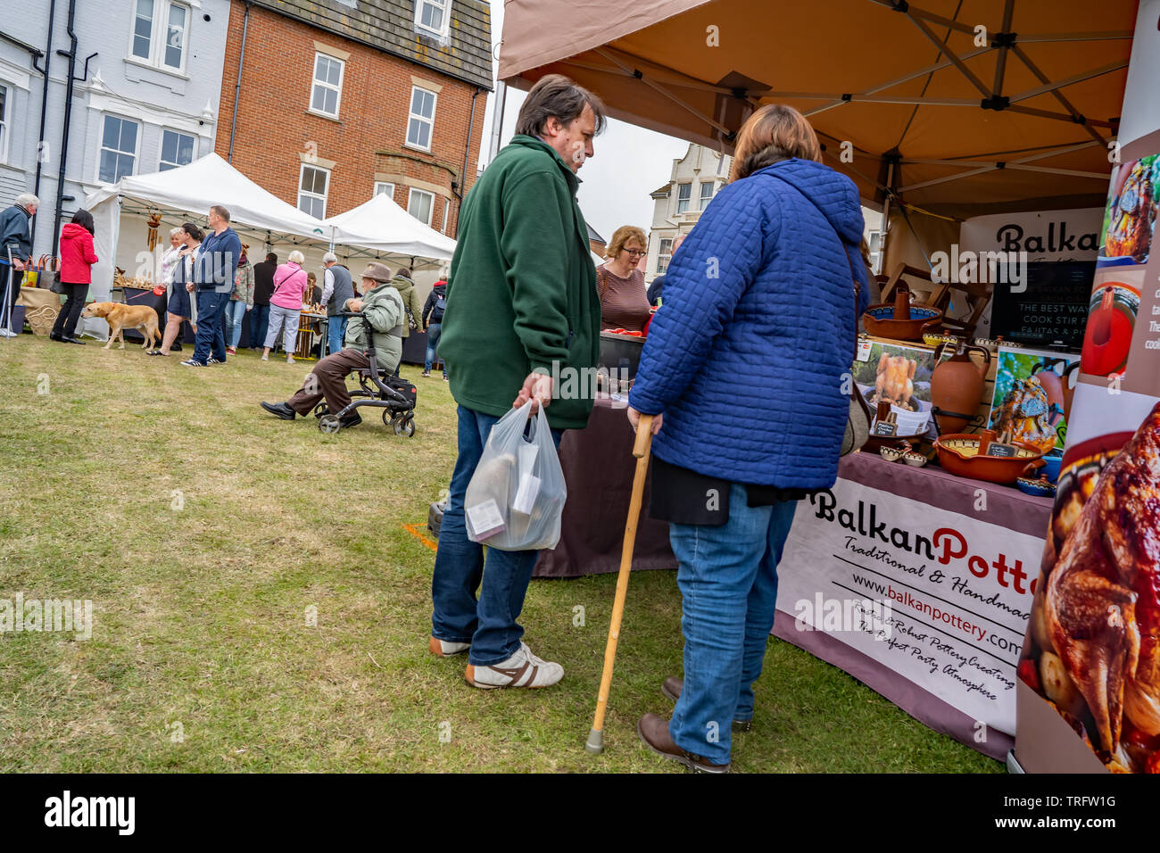 Cromer, Norfolk, Großbritannien. 19. Mai 2019. Cromer Krabben und Hummer Festival - ein Paar mittleren Alters aus einem Mann, der eine grüne und eine blaue Jeans holdi Stockfoto