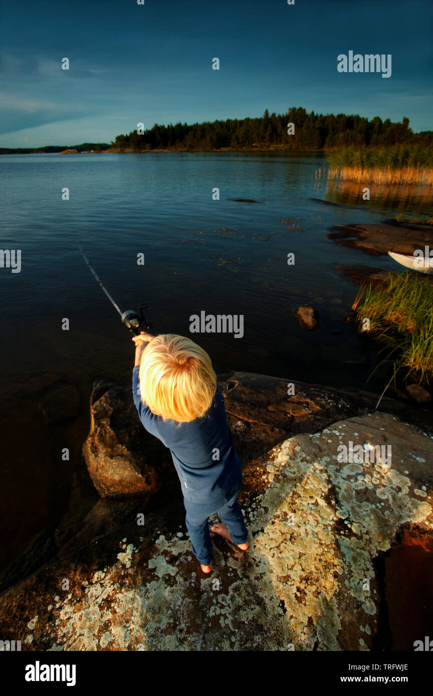 Ein Junge ist das Angeln auf der Insel im See Brattholmen Vansjø, Østfold, Norwegen. Vansjø ist der größte See in Østfold. Der See Vansjø und die umliegenden Seen und Flüsse sind ein Teil des Wassers, das System namens Morsavassdraget. September, 2006. Stockfoto